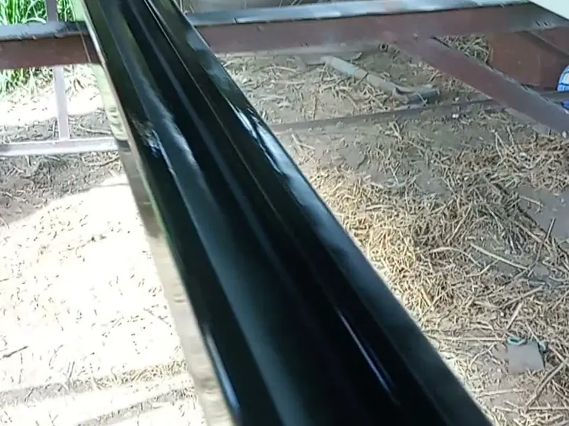 Canaleta metálica negra instalada junto a una estructura